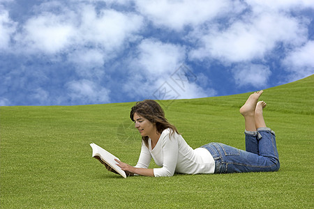 在公园里读取季节草原女性喜悦阅读身体草地娱乐微笑时间图片