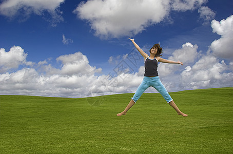 快乐的跳跃假期闲暇女性运动员喜悦旅行场地草地力量蓝色图片