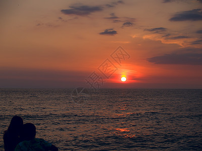 在海边的一对夫妇假期场景享受海浪日落天空海滩蜜月天堂成人图片