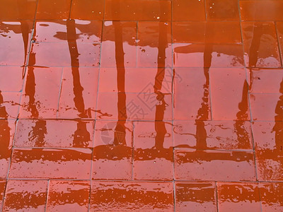 在雨中反射人行道红色天空水坑下雨路面风暴街道场景城市天气图片