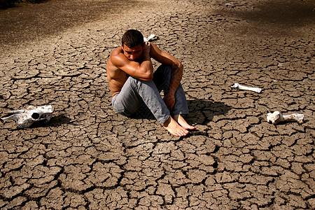 人坐在荒地上危机地球地面压力中年人土壤中年焦土干旱人体图片