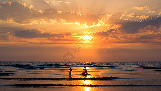 日落在海面上乐趣橙子梯度波浪孩子们海洋涟漪阳光活动反射图片