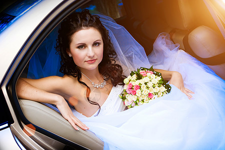 在婚礼车里的美容裙子订婚化妆品庆典喜悦微笑花束太阳新娘花朵图片