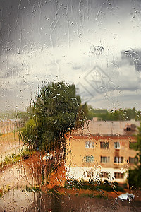 窗外的雨玻璃风暴风景雨滴灰色房子液体反射天气季节图片