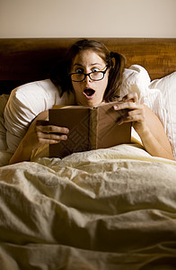 床上妇女阅读悬念眼镜枕头小说女士就寝时间床单失眠惊喜图片