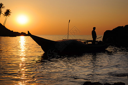 船上有渔网的渔民海洋渔夫钓鱼海滩工作杂草橙子日落蓝色旅游图片