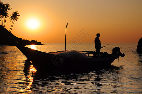 船上有渔网的渔民波纹热带男人钓鱼海滩传统日落蓝色旅游皮艇图片