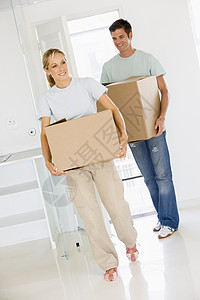 一对夫妇带着盒子搬进新家 微笑着公寓房子房地产女性情感房间购买者女子男性抵押图片