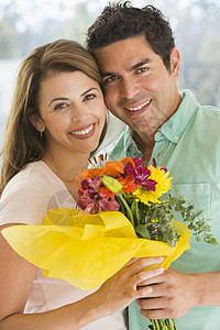 丈夫和妻子拿着鲜花 微笑着笑容男性夫妻感情生日女性两个人拉丁惊喜伙伴展示图片
