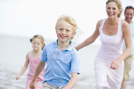 家人在海滩上欢笑着奔跑男人跑步微笑父亲假期女士天空女性妈妈女儿图片