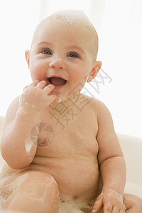泡泡浴中的婴儿橡皮洗澡孩子们头发孩子浴缸沐浴相机微笑女孩图片