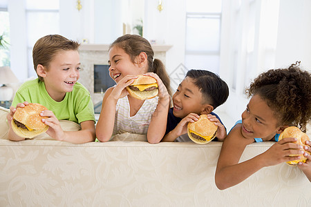 4个小孩在客厅吃芝士汉堡 笑着四个人孩子女性孩子们水平乐趣男生儿童食物食品图片