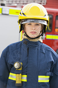 一名消防员站在消防车前的肖像英雄服务情况手电筒女性消防服好榜样消防火炬头盔图片