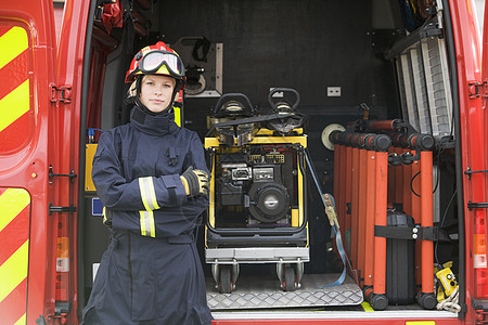 消防员站在一个小型消防机设备旁站立的消防员单位起重消防队员工具服务好榜样救援头盔情况风镜图片