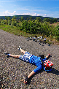 疲劳骑自行车者女士蓝色灌木丛沥青短裤白色红色天空手套太阳图片