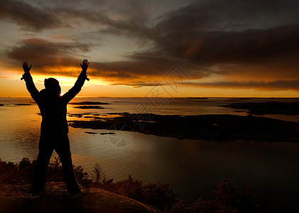 海洋庆祝太阳享受天空岩石温暖女性日落峡湾海岸手臂图片