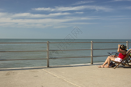 预演甲板栏杆椅子蓝色海滩女士安全长廊图片