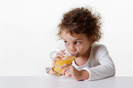 喝橙汁的小女孩孩子水果卷曲液体橙子玻璃眼睛女孩精力饮食图片