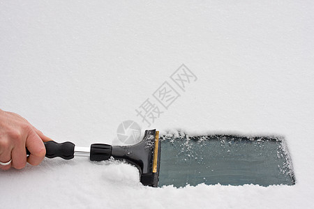 手与一个擦冰机 清理挡风玻璃雪花刮刀天气运输戒指汽车车辆驾驶打扫温度图片