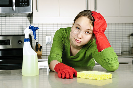 疲累的女孩清洁厨房海绵瓶子女士管家挫折清洁剂青少年房子女性抛光图片
