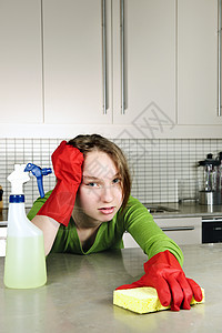 疲累的女孩清洁厨房女孩们柜台挫折抛光海绵家政琐事橡皮打扫消毒剂图片