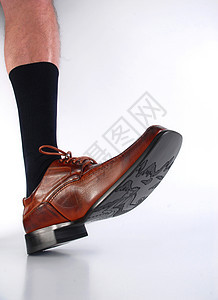 黑色袜子和棕色鞋的男性毛腿图片