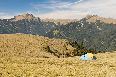 在高山草原上设置特别帐篷太阳阳光游客风景背包假期运动木头蓝色公园图片