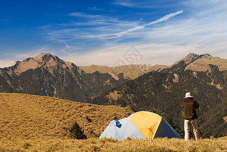 在高山草原上设置特别帐篷远足运动木头风景阳光娱乐太阳背包庇护所男人图片