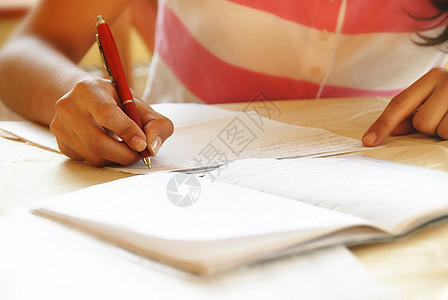 女学生做功课笔记女性桌子学校字母测试青少年学习教育写作图片