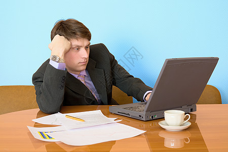 用笔记本电脑在工作场所工作的商务人士文档商务忧郁男性衬衫桌子咖啡写字桌飞碟地点图片
