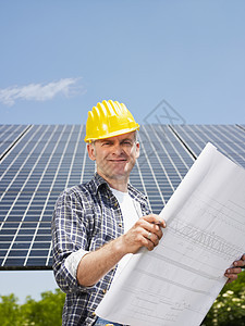 靠近太阳能电池板的电工技术环境男性收藏家快乐男人中年人检查工程师蓝图图片