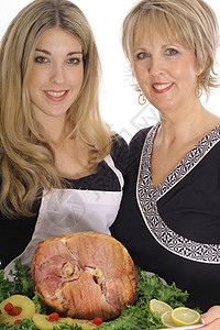 母亲和女儿一起煮火腿 孤立在白色上图片
