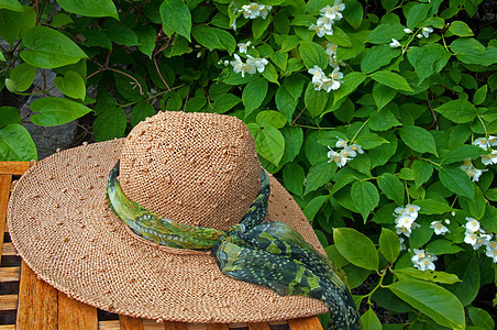 草帽放在花园的桌子上图片
