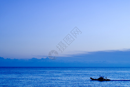 一艘在大洋中的船旅游游客气氛航行天空海浪钓鱼海景日出海岸图片