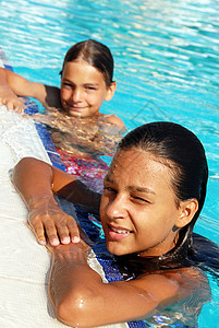 在游泳池中微笑儿童女性假期女孩喜悦孩子们青少年太阳游泳阳光游泳者图片