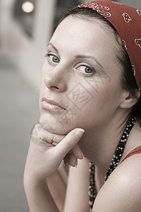 穿着红手巾的不快乐女人黑发红色头巾城市悲伤紫色蝴蝶女士深色手指图片