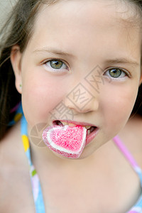 美丽的青少年肖像 吃糖果心图片