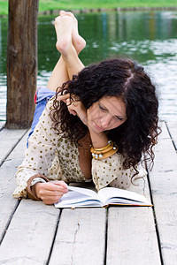 一位美貌女性在阅读书的户外肖像图片