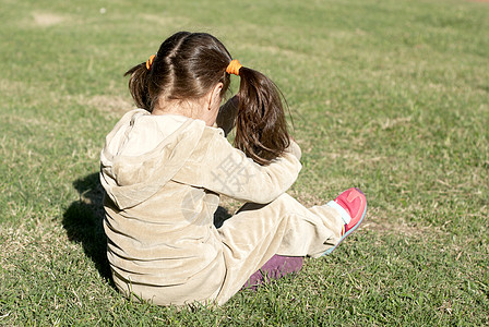 那个在草地上停车的受罪女孩绿色压力孩子公园拉丁拥抱头发情绪哭泣黑发图片