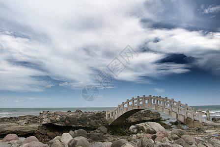 近海边岩石上的桥地平线假期太阳日出天空海岸线海浪海洋天堂冲浪图片