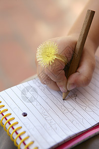 儿童手持滑稽黄色戒指 写在笔记本上图片