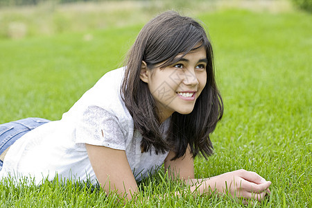躺在草地上美丽的少女女孩青少年混血混血儿女性说谎绿色场地时光背景图片