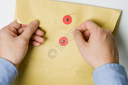 手打开保密信封袋商业文档办公室邮资邮政服务概念回收派遣机密图片