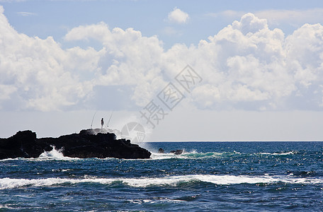 岩石上一个渔民的休睡轮椅图片