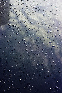 金属表面的水滴与天空反射图片