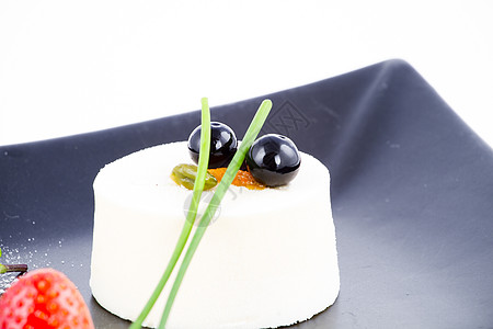 香草慕斯甜点 在黑白盘上加红莓盘子树叶圆柱薄荷暗示食物冰糖平方雪花痕迹背景图片