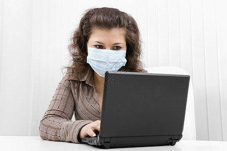 戴笔记本电脑医疗面具的年轻妇女疾病工作女孩疼痛女士训练商业温度互联网传染性图片