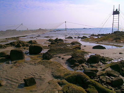 沿海海滨蓝色天空太阳渔夫岩石棕色旅行支撑海洋水池图片