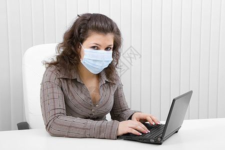 戴笔记本电脑医疗面具的年轻妇女女士温度传染性黑发互联网商业女孩工作训练疼痛图片