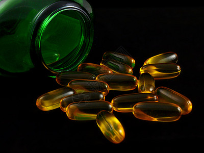 鱼油补给药片黄色食物卫生背景黑色维生素海鲜营养医疗图片